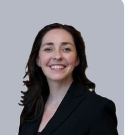 Mary McMahon Smiling dark hair wearing a black suit jacket