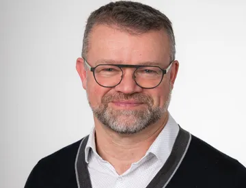 Liz Grennan smiling waering a red top